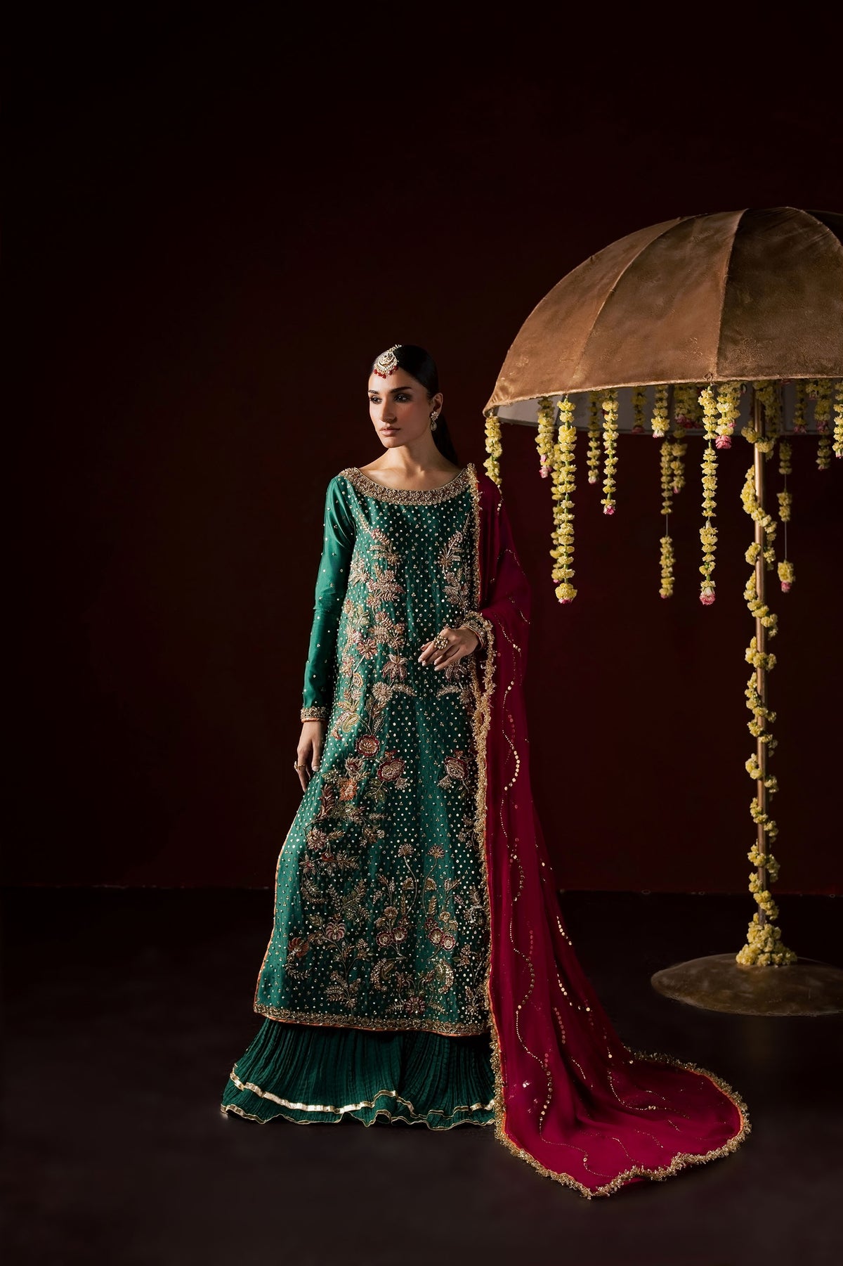 Zonaira Ahmed Haya emerald green maroon wedding formal 3-piece – full-length front view beside decorative umbrella prop