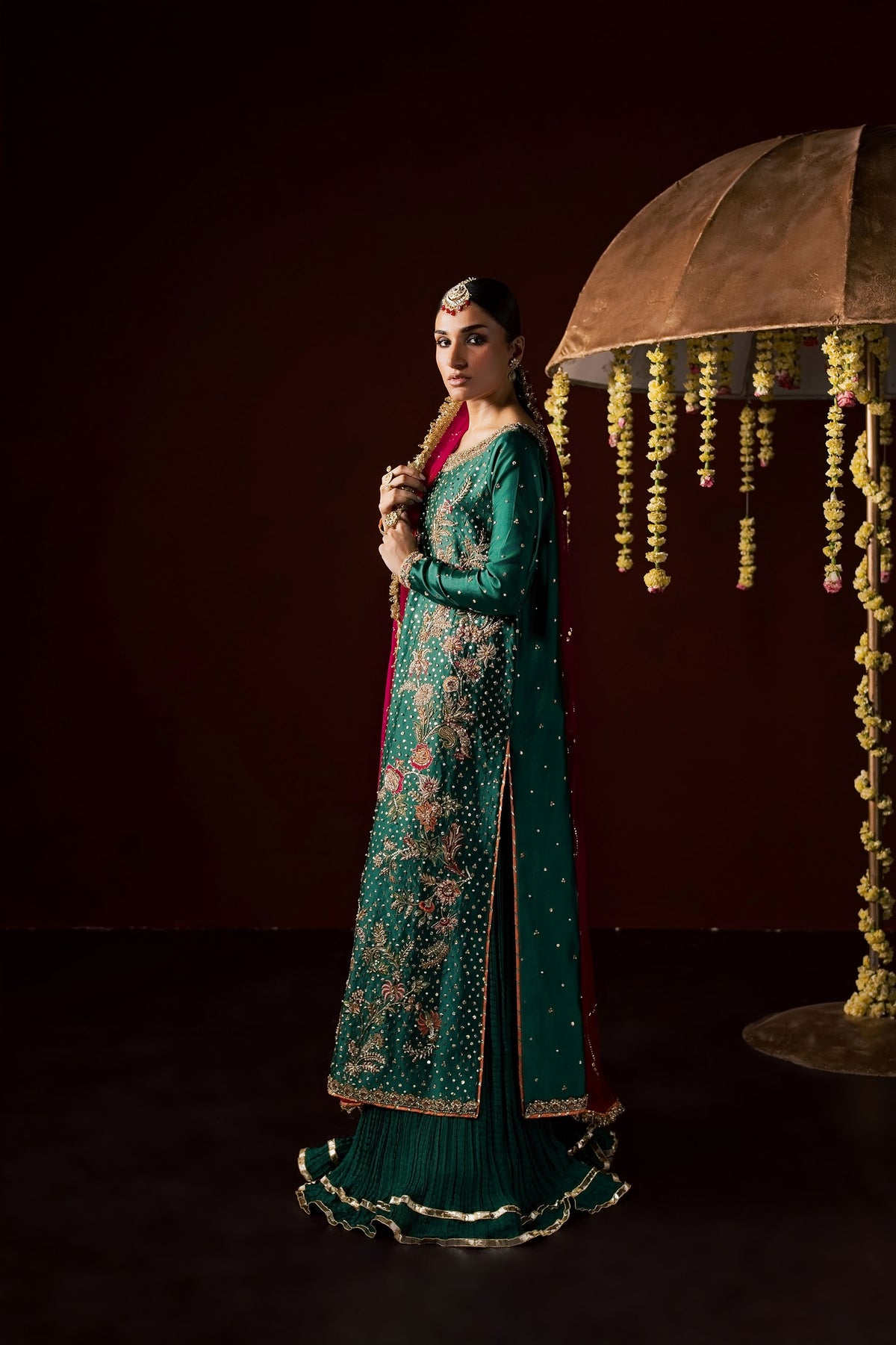 Zonaira Ahmed Haya emerald green maroon wedding formal 3-piece – full-length side profile beside umbrella prop