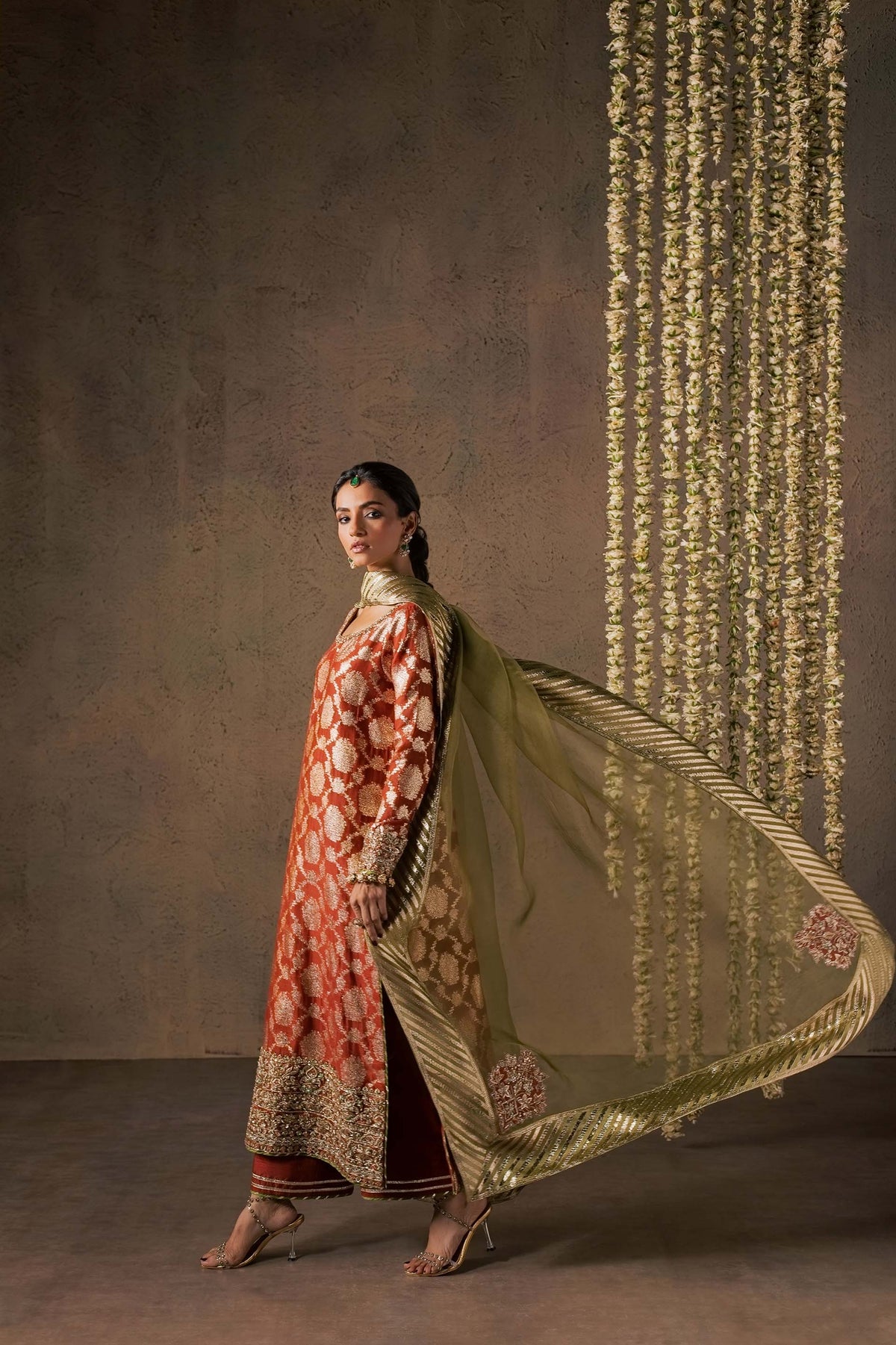 Zonaira Ahmed Mehr rust gold wedding formal 3-piece – walking shot with the dupatta swirling dramatically to one side