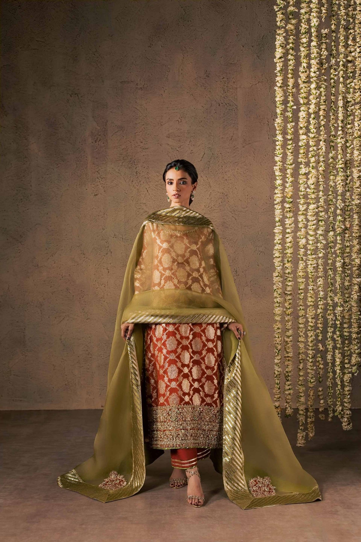 Zonaira Ahmed Mehr rust gold wedding formal 3-piece – front view with the dupatta draped over the head like a veil, hands holding the corners