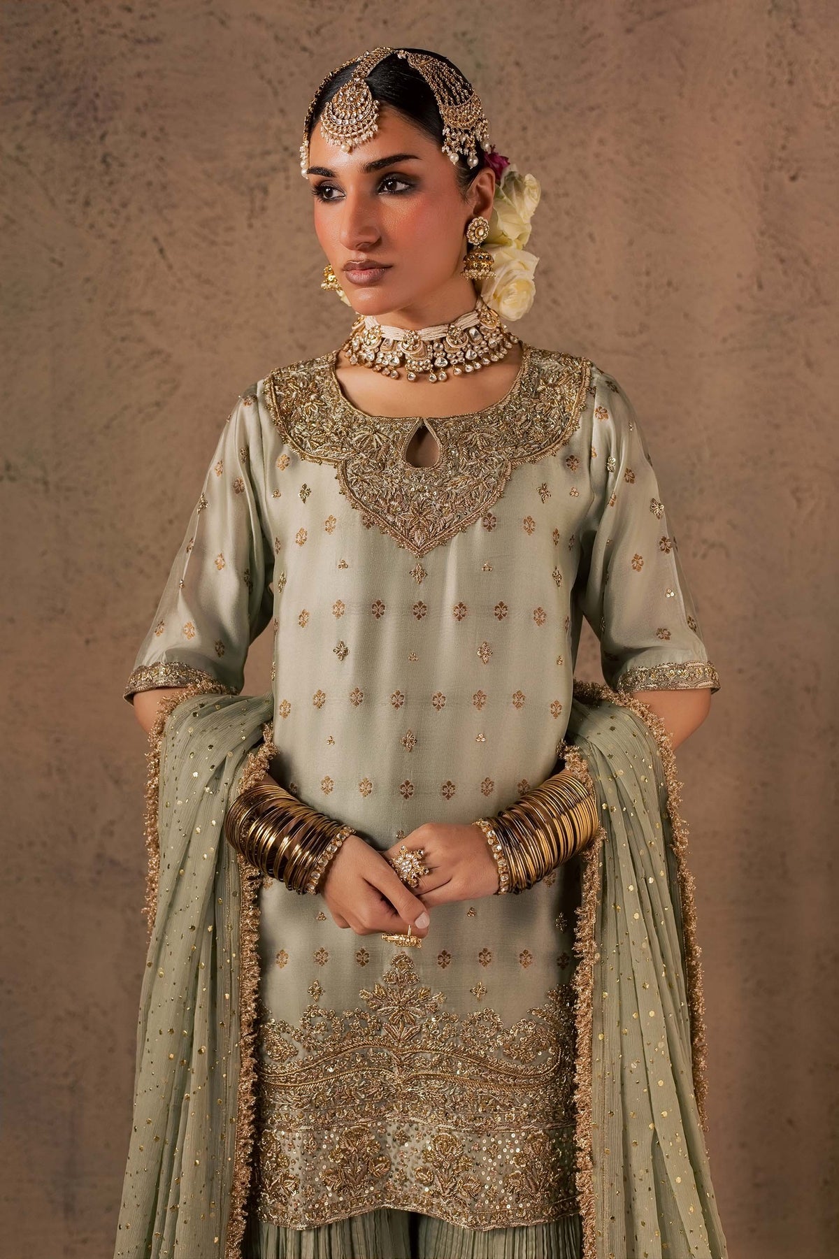 Zonaira Ahmed Naaz sage green wedding formal 3-piece – half-body front view with hands clasped, hem embroidery visible