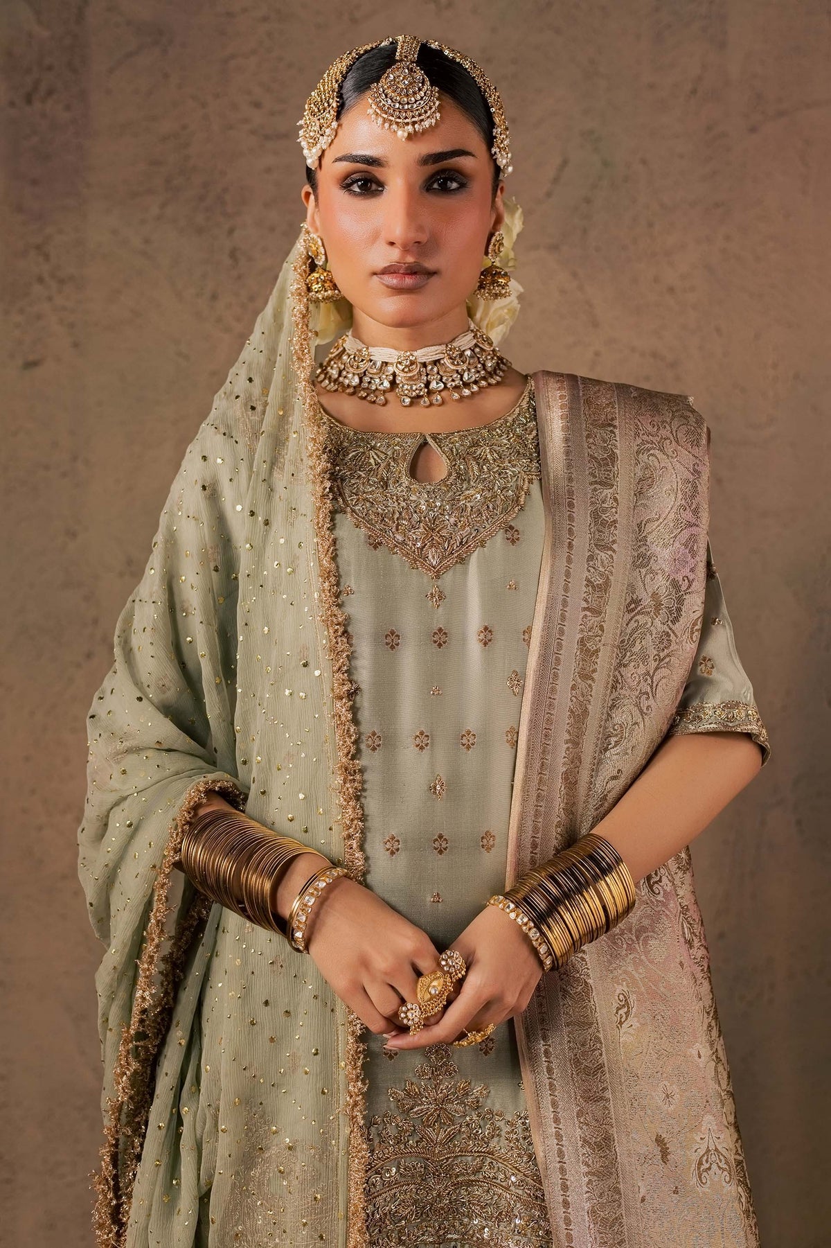 Zonaira Ahmed Naaz sage green wedding formal 3-piece – medium shot with hands clasped, neckline and jewelry visible