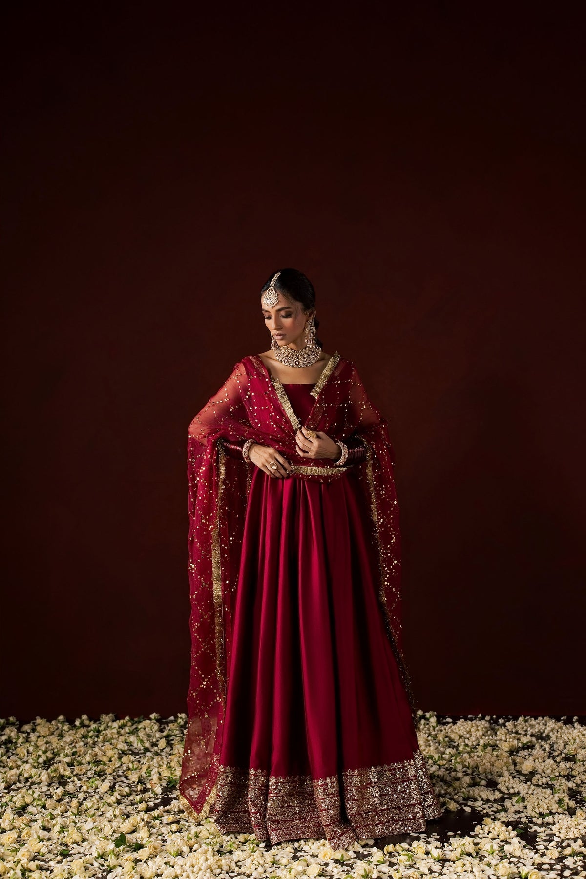 Zonaira Ahmed Neysa maroon wedding formal peshwas – front view with the gold mukesh dupatta draped over both shoulders, hands folded