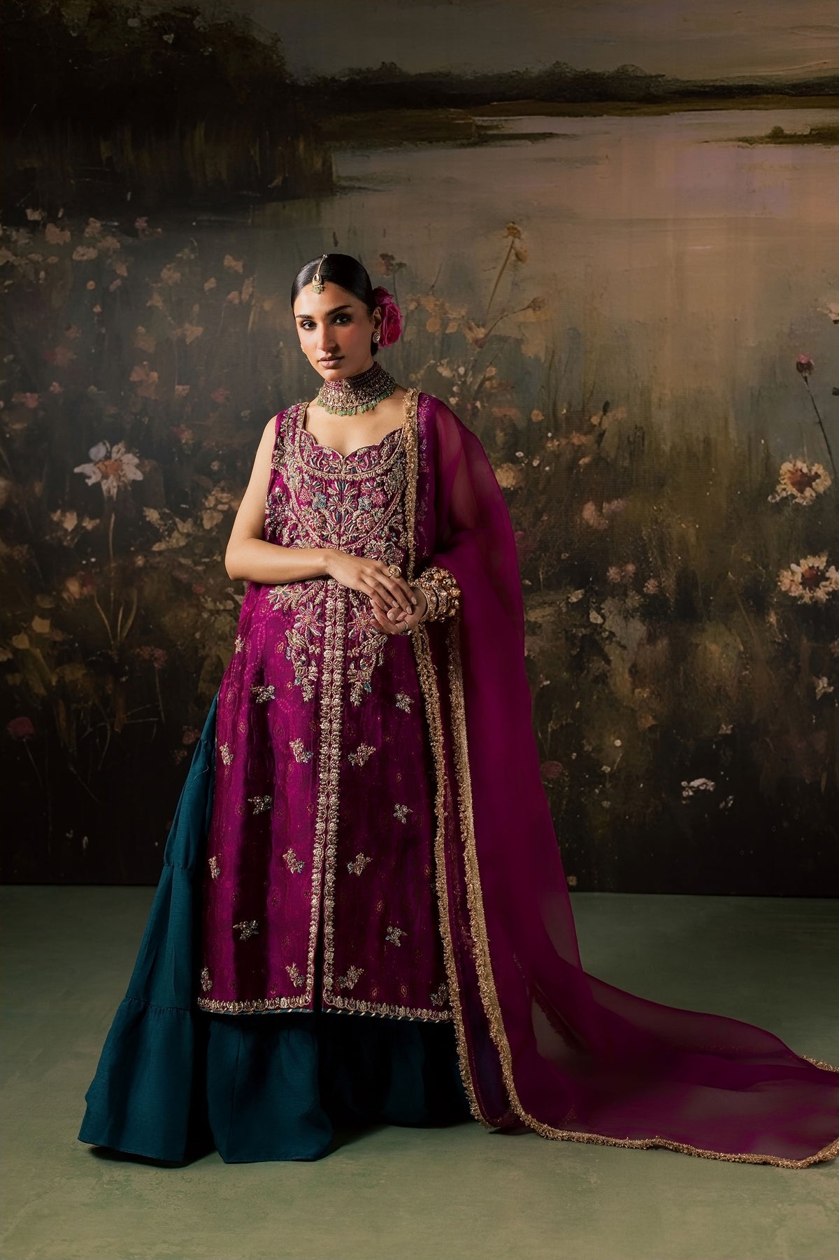 Zonaira Ahmed Rania magenta teal wedding formal 3-piece – full-length front view, hands clasped, painted floral lake backdrop