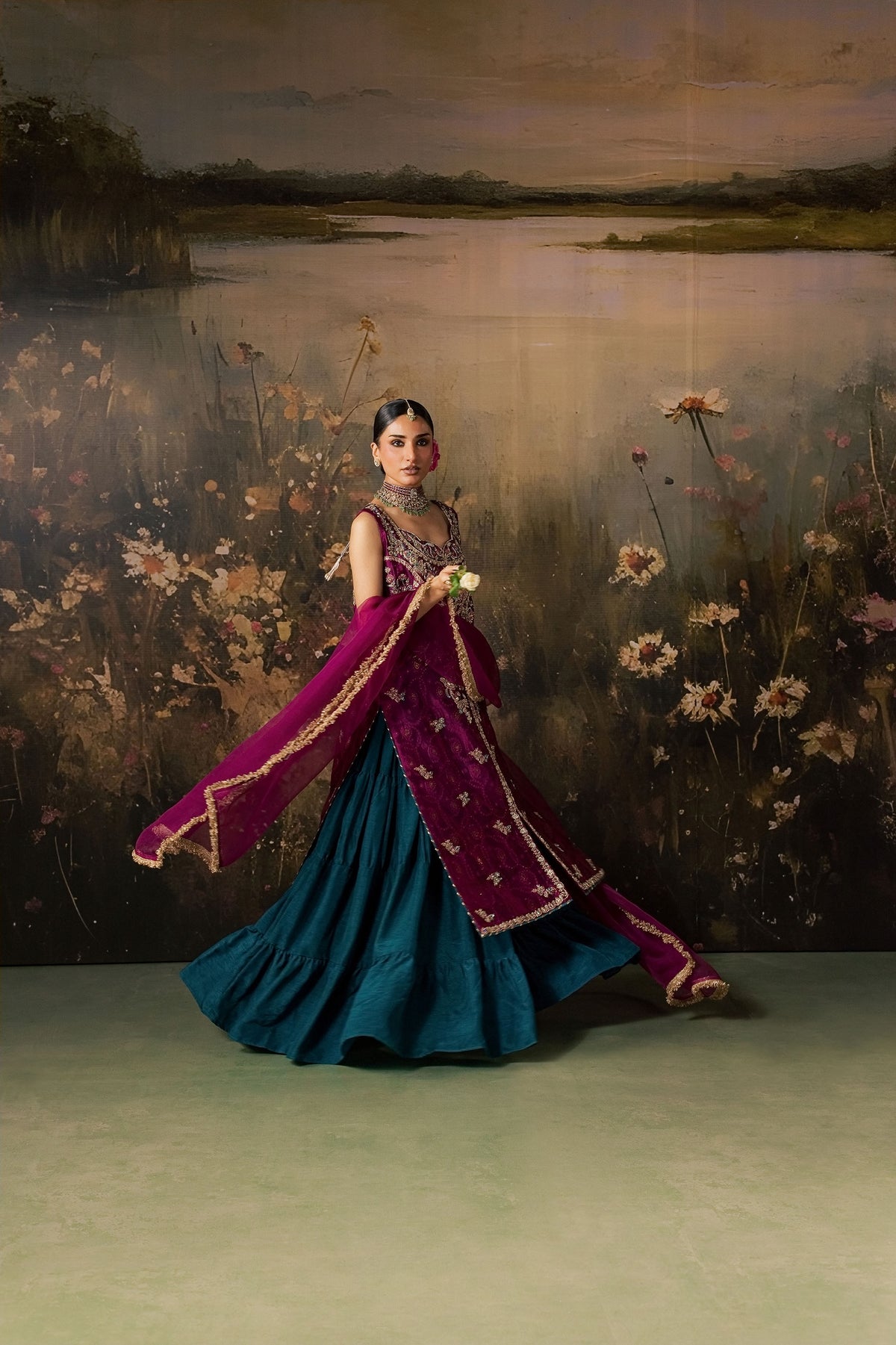 Zonaira Ahmed Rania magenta teal wedding formal 3-piece – twirl shot showing teal skirt movement and magenta dupatta flowing, painted floral lake backdrop